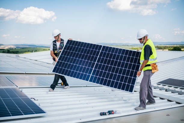 Team of solar energy workers installing solar panels system.